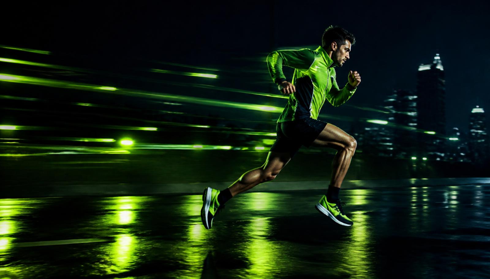 Atleta correndo à noite em ritmo acelerado